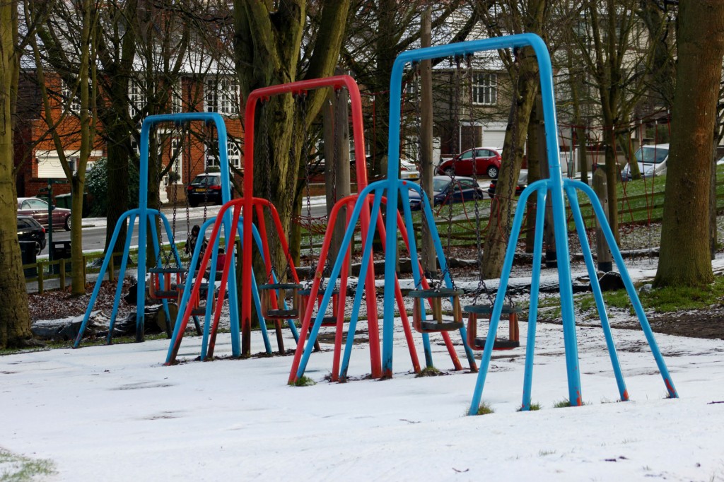 Children's swings surrounded by snow