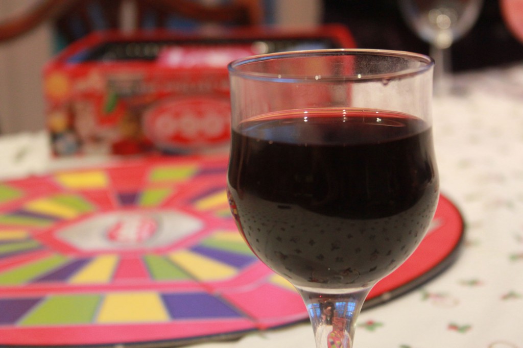 Wine glass filled with Red wine in from of a board game